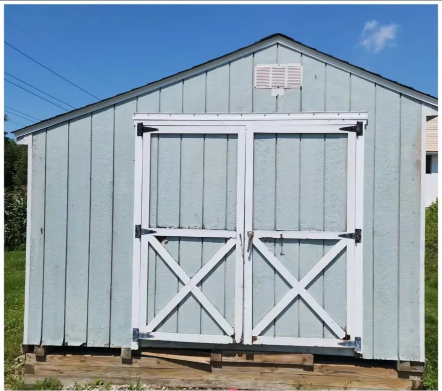Before shed repaint: faded green shed siding with weathered white doors