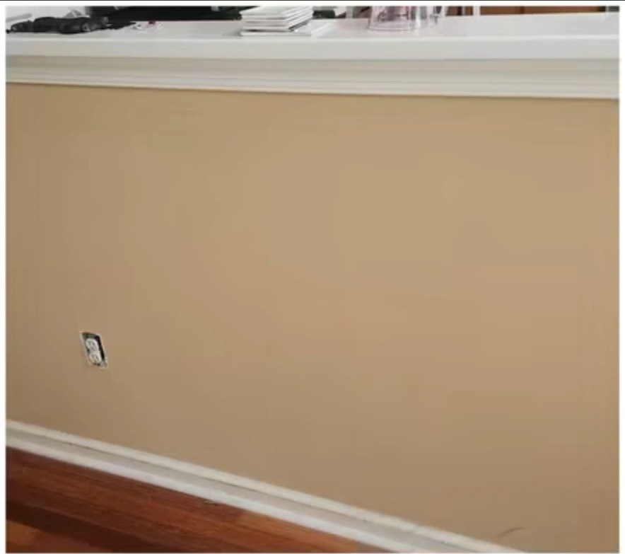 Before interior painting: tan painted wall below a half wall with crown molding