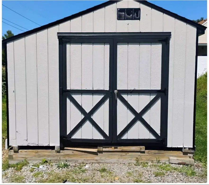 After shed repaint: white shed siding with black-trimmed doors